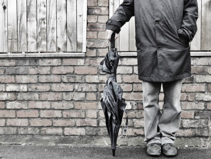 man in mac with umbrella